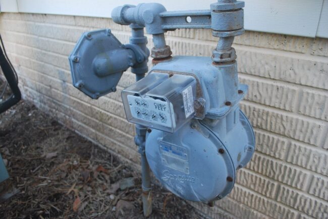 Gas meter installed on a brick exterior wall, indicating gas line infrastructure relevant to plumbing services and maintenance.