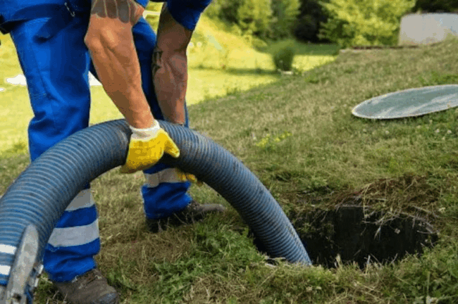 Plumber using a drain cleaning hose to clear a clogged drain in Odessa, Texas, emphasizing professional plumbing services.