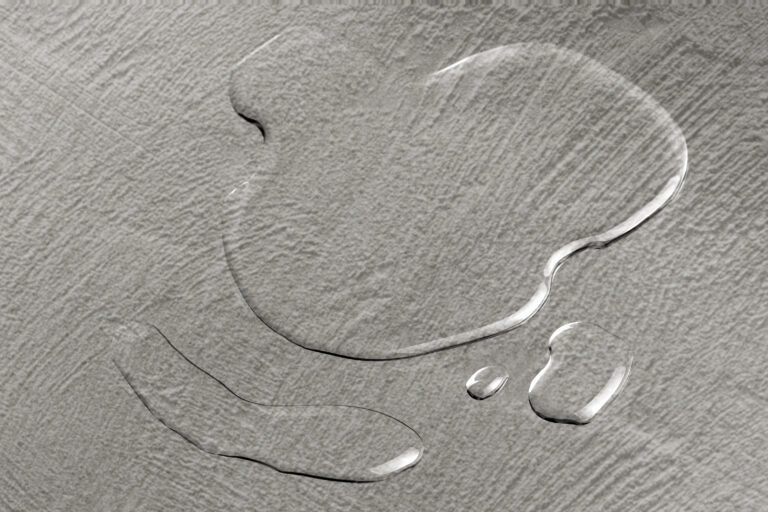 small puddles of water on a textured gray floor
